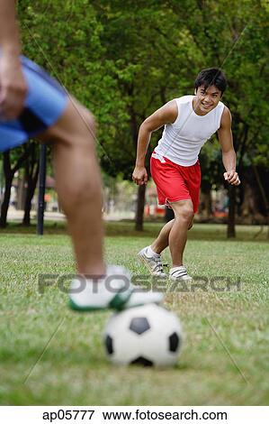Two men playing soccer View Large Photo Image Stock Photo - Two men playing soccer. Fotosearch