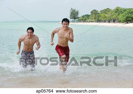 Two men running along the beach View Large Photo Image Picture - Two men running along the beach. Fotosearch