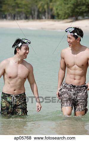 Two men wading in sea, wearing goggles View Large Photo Image Stock Photo - Two men wading in sea, wearing goggles. Fotosearch