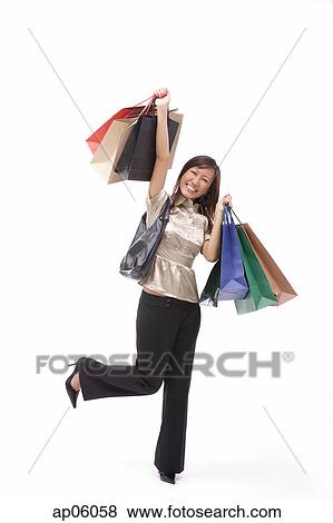 Woman carrying shopping bags, arms outstretched View Large Photo Image Stock Photo - Woman carrying shopping bags, arms outstretched. Fotosearch