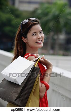 Woman carrying shopping bags over shoulder View Large Photo Image Stock Image - Woman carrying shopping bags over shoulder. Fotosearch
