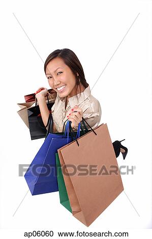 Woman carrying shopping bags, smiling at camera View Large Photo Image Stock Image - Woman carrying shopping bags, smiling at camera. Fotosearch