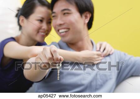Woman embracing man from behind, man holding keys View Large Photo Image Stock Photo - Woman embracing man from behind, man holding keys. Fotosearch