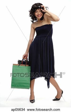 Picture - Woman in black dress, carrying shopping bags. Fotosearch