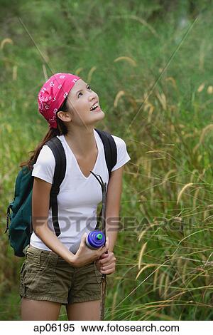 Woman on hiking trail, looking up, smiling View Large Photo Image Stock Photography - Woman on hiking trail, looking up, smiling. Fotosearch