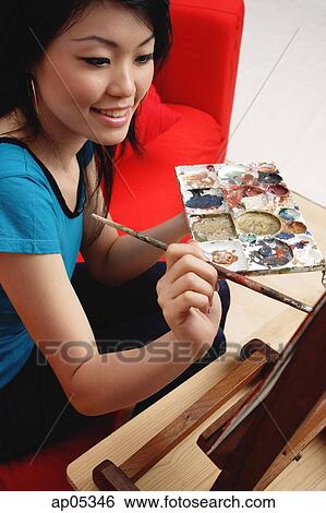 Woman painting, holding palette View Large Photo Image Stock Photograph - Woman painting, holding palette. Fotosearch