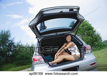 Woman sitting in boot of car, smiling View Large Photo Image Stock Photo - Woman sitting in boot of car, smiling. Fotosearch