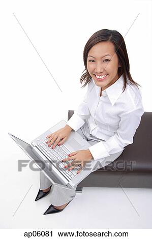 Woman sitting on bench with laptop, smiling at camera View Large Photo Image Stock Image - Woman sitting on bench with laptop, smiling at camera. Fotosearch