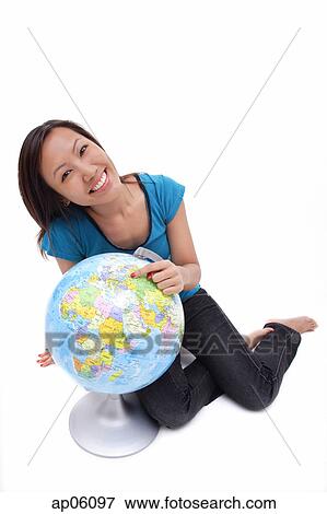 Stock Photo - Woman sitting on floor with globe. Fotosearch