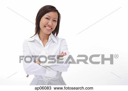Stock Image - Woman with arms crossed, smiling at camera. Fotosearch