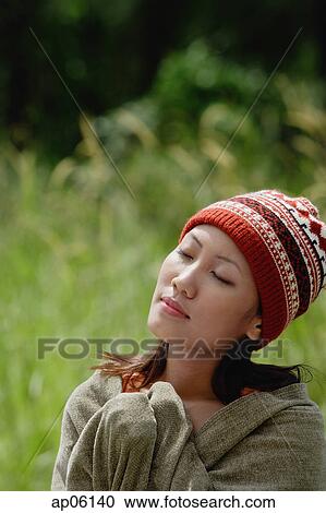 Woman with ski cap, wrapped in a blanket, eyes closed View Large Photo Image Stock Image - Woman with ski cap, wrapped in a blanket, eyes closed. Fotosearch