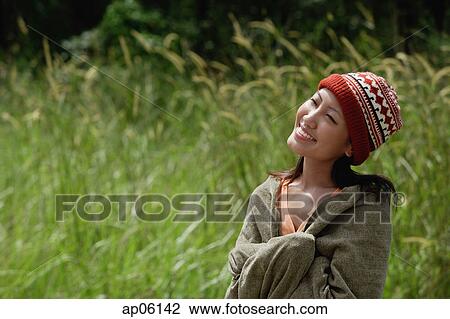 Woman wrapped in a blanket, smiling View Large Photo Image Stock Image - Woman wrapped in a blanket, smiling. Fotosearch