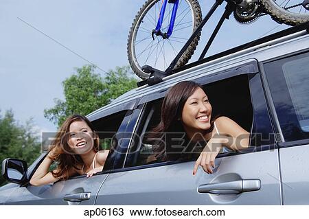 Women leaning out of car window, looking away View Large Photo Image Stock Image - Women leaning out of car window, looking away. Fotosearch