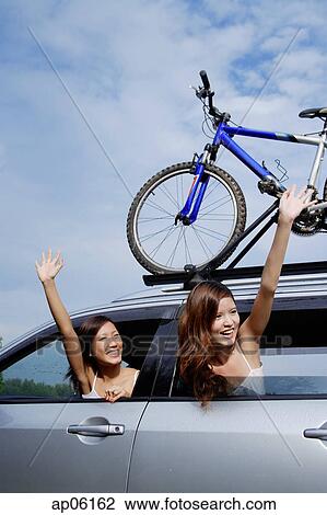 Women leaning out of car window, waving View Large Photo Image Stock Image - Women leaning out of car window, waving. Fotosearch