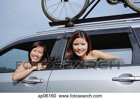 Women looking out of car window, smiling at camera View Large Photo Image Stock Image - Women looking out of car window, smiling at camera. Fotosearch
