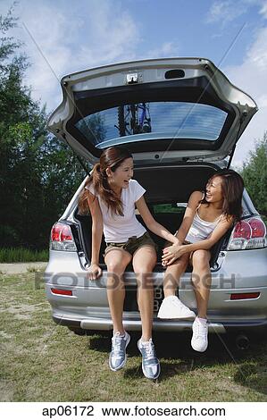 Women sitting in boot of car, laughing View Large Photo Image Stock Image - Women sitting in boot of car, laughing. Fotosearch