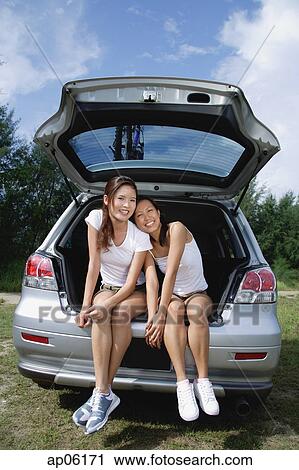 Women sitting in boot of car View Large Photo Image Stock Image - Women sitting in boot of car. Fotosearch