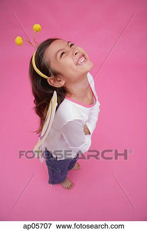 Young girl wearing fairy wings and deely bopper, arms crossed, looking up View Large Photo Image Stock Photo - Young girl wearing fairy wings and deely bopper, arms crossed, looking up. Fotosearch