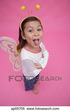 Young girl wearing fairy wings and deely bopper, arms crossed, sticking out tongue View Large Photo Image Stock Photography - Young girl wearing fairy wings and deely bopper, arms crossed, sticking out tongue. Fotosearch