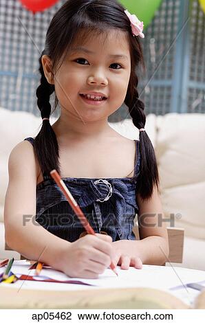 Young girl with pencil and paper, smiling at camera View Large Photo Image Stock Image - Young girl with pencil and paper, smiling at camera. Fotosearch