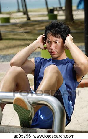 Stock Photograph - Young man doing sit ups. Fotosearch
