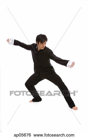 Young man practicing martial arts in studio View Large Photo Image Stock Photograph - Young man practicing martial arts in studio. Fotosearch