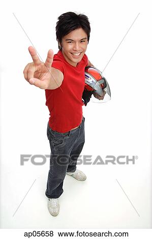 Stock Photo - Young man with motorcycle helmet, making peace sign. Fotosearch