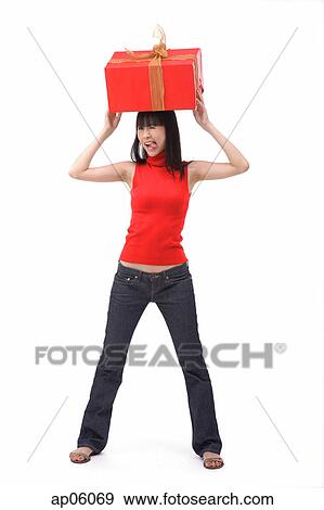 Young woman balancing big red gift box on her head View Large Photo Image Stock Photo - Young woman balancing big red gift box on her head. Fotosearch