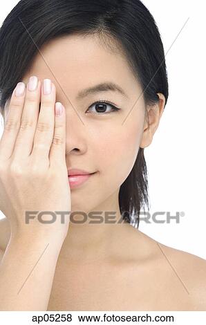 Stock Photo - Young woman covering half her face with her hand. Fotosearch