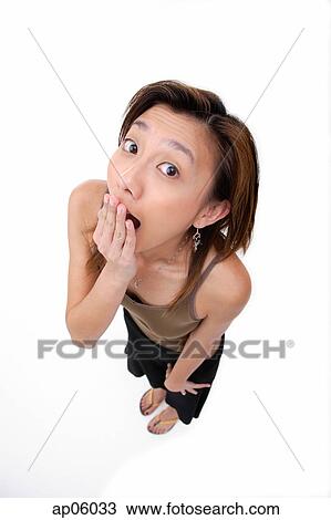 Young woman covering mouth, looking at camera View Large Photo Image Stock Image - Young woman covering mouth, looking at camera. Fotosearch