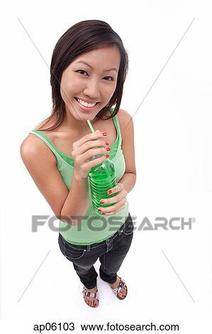 Stock Image - Young woman drinking from bottle. Fotosearch