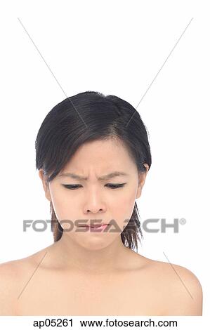 Young woman frowning, looking down View Large Photo Image Stock Image - Young woman frowning, looking down. Fotosearch