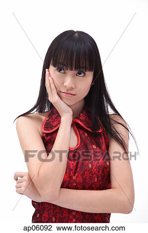 Stock Image - Young woman, hand on face, looking away. Fotosearch