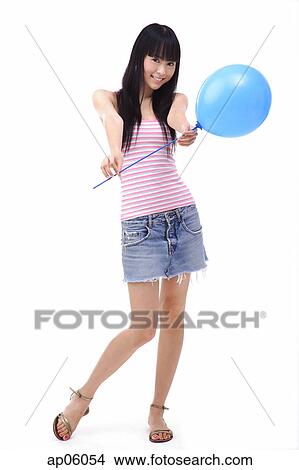 Young woman holding a blue balloon towards camera View Large Photo Image Picture - Young woman holding a blue balloon towards camera. Fotosearch