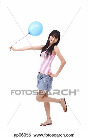 Young woman holding a blue balloon, standing on one leg View Large Photo Image Stock Photography - Young woman holding a blue balloon, standing on one leg. Fotosearch