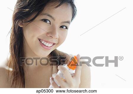 Young woman holding bottle, looking at camera View Large Photo Image Stock Image - Young woman holding bottle, looking at camera. Fotosearch