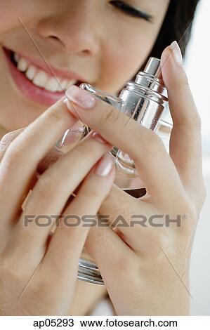 Young woman holding perfume bottle View Large Photo Image Stock Image - Young woman holding perfume bottle. Fotosearch