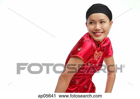 Stock Image - Young woman in cheongsam looking away. Fotosearch