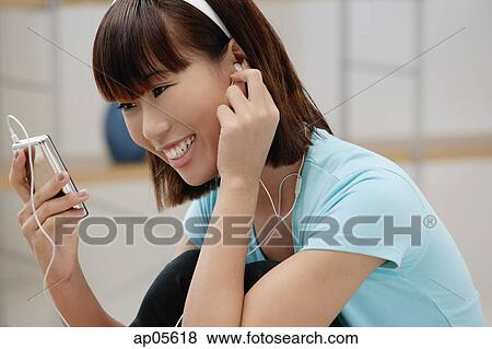 Young woman listening to MP3 player View Large Photo Image Stock Photo - Young woman listening to MP3 player. Fotosearch