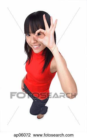 Stock Image - Young woman making Ok sign with fingers. Fotosearch