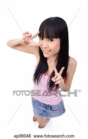 Stock Photograph - Young woman making peace sign, smiling. Fotosearch