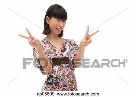 Stock Photo - Young woman making peace sign with fingers. Fotosearch