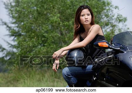 Young woman on motorcycle, looking at camera View Large Photo Image Stock Photo - Young woman on motorcycle, looking at camera. Fotosearch
