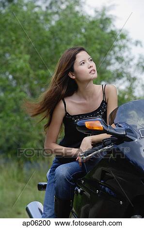 Young woman on motorcycle, looking away View Large Photo Image Stock Image - Young woman on motorcycle, looking away. Fotosearch