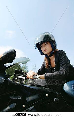 Young woman riding motorbike, low angle view View Large Photo Image Stock Photography - Young woman riding motorbike, low angle view. Fotosearch