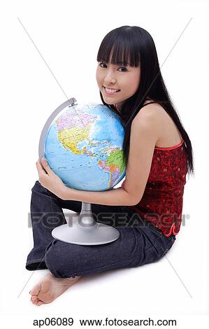 Young woman sitting on floor, embracing globe, smiling at camera View Large Photo Image Stock Photo - Young woman sitting on floor, embracing globe, smiling at camera. Fotosearch