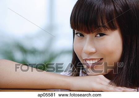 Young woman smiling at camera, head shot View Large Photo Image Stock Image - Young woman smiling at camera, head shot. Fotosearch
