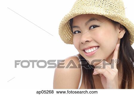 Stock Photo - Young woman wearing hat, hand on chin. Fotosearch