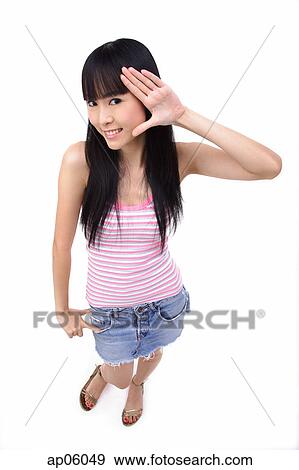 Stock Photo - Young woman with hand on face, smiling at camera. Fotosearch