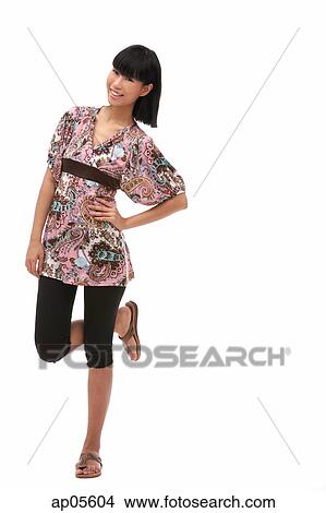 Young woman with hand on hip, standing on one leg View Large Photo Image Picture - Young woman with hand on hip, standing on one leg. Fotosearch